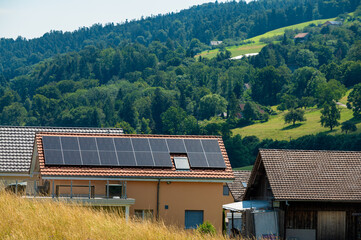 Pitched roof house with solar panels on rooftop at Swiss village  Switzerland. 
