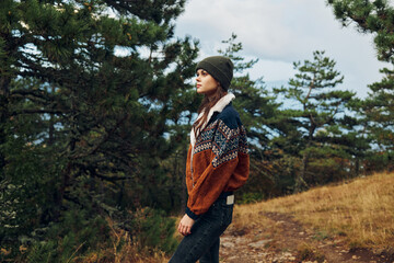 Naklejka premium A young woman exploring the tranquil beauty of nature on a forest trail in stylish attire