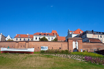 Zabytkowa brama oraz historyczna łódka z kultowego filmu, bulwar nad rzeką, Toruń, Polska. Historic gate in Torun, Poland  © 123108 Aneta