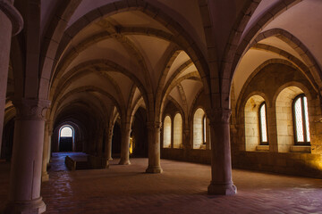 cloister with a series of arches supported by elegant columns, creating a grand and awe-inspiring interior space bathed in warm light