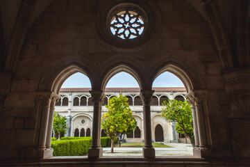 a picturesque view through a series of arched windows within a historic cloister
