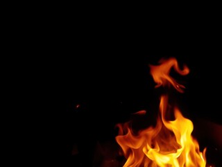 Fototapeta premium Abstract fire flames swirling on a dark black background, dark, abstract