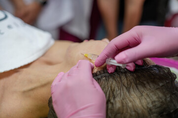 The master cosmetologist shows cosmetology students the technique of how to do biovelitarization in the face. Cosmetology. Youth. Beauty