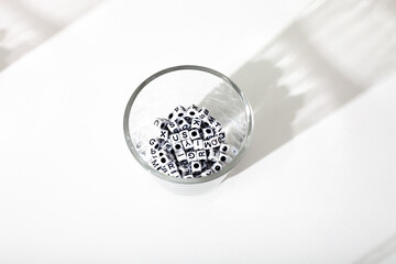 small dice with letters in a glass