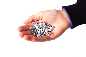 Child holding small dice with letters