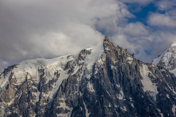 Aiguille du Midi peak in the Alps. Chamonix valley landscape of a prominent rocky towering mountain peak in french Alps. Chamonix-Montblanc area beautiful landscape of Aiguille du Midi summit