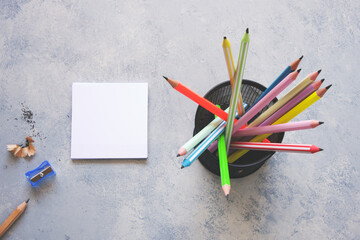 Blank paper, pencil, eraser and sharpener on gray background