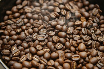 Closeup of freshly roasted coffee beans, steam rising, highlighting rich aroma and glossy surface.