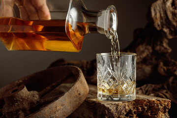Whiskey is poured from a decanter into a glass.
