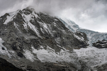 Obraz premium Breathtaking winter landscape featuring snow-covered mountains under a beautiful misty sky.