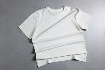One t-shirt on grey textured background, top view