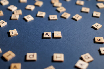 AI word displayed in wooden letter tiles scattered across a blue surface