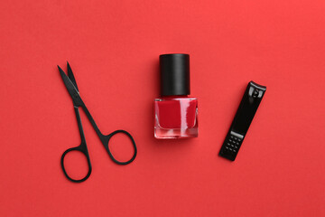 Set of pedicure tools on red background, flat lay