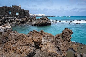 picturesque fishing village in Punta Mujeres, Lanzarote, with the facade of a house covered with volcanic rocks