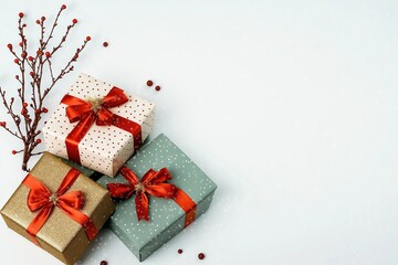 Christmas gifts wrapped in festive wrapping paper with red ribbons, snowflakes. Decorative branches...