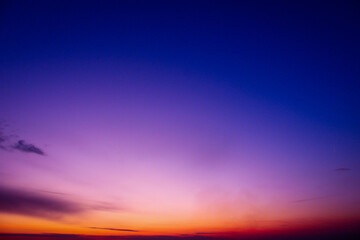 a purple sky with a purple and orange horizon and a purple cloud. Dramatic sky