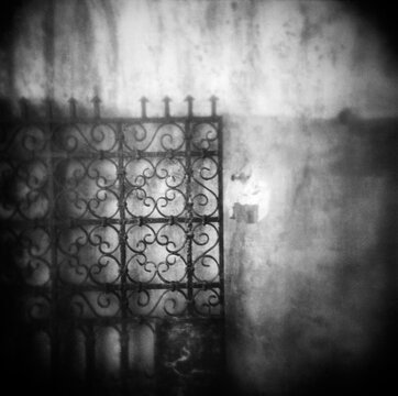 Black and white image of a metal gate leaning agains a wall, Rabat, Morocco