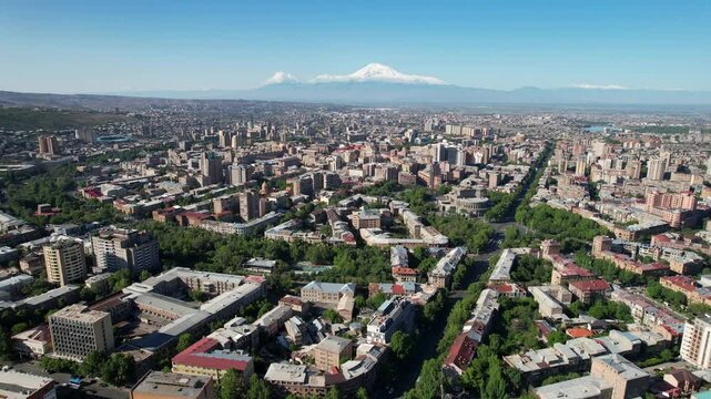 Sliding aerial shot of central part of Yerevan, Cascade Complex and Mount Ararat on sunny summer day. Armenia.