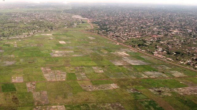 Aerial view flying over the tropical West African city of Lom&eacute;, Togo and surrounding farms and rice fields.