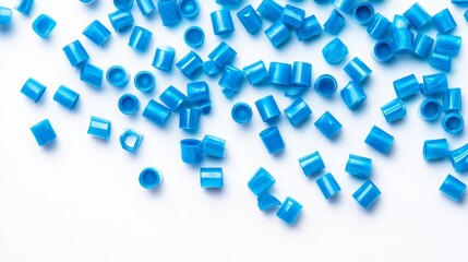 15.Isolated image of individual blue plastic caps scattered across a bright white background, showing the texture and shine of the caps under soft lighting.