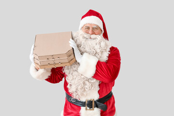 Santa Claus with pizza boxes on white background