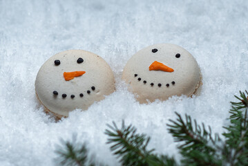 Christmas ornament on macarons. White macaroons are lying on the snow