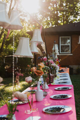 Whimsical Outdoor Tablescape with Hanging Lampshades, Floral Arrangements, and Vibrant Decor for Wedding or Event Inspiration