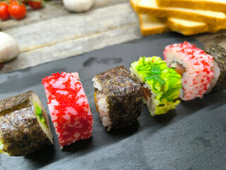 Delicious sushi rolls on a granite chopping board.