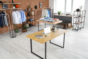 Interior of men's clothing store with shelf units and tables
