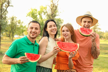 Young friends with slices of watermelon on picnic in park