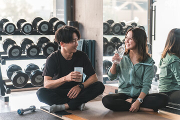 休憩・水分補給をするスポーツジムに通う男性と女性・カップル
