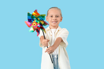 Funny little girl with toy windmill  on blue background