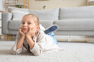 Funny little girl lying on carpet