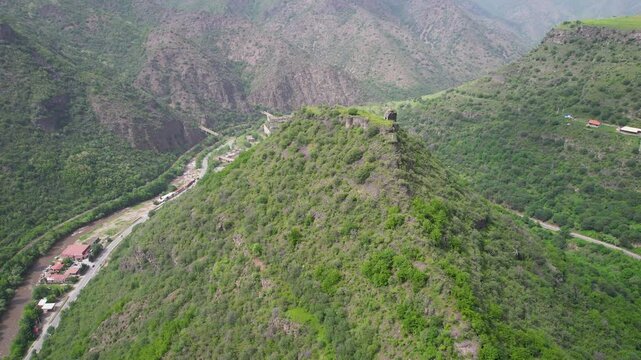 Forward reveal aerial shot of remains of Kayan Fortress on sunny spring day. Haghpat, Armenia.