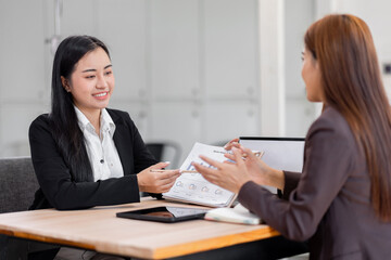 Business financing accounting banking concept. Two asian Business doing finances and calculate on desk about cost at workplace. Business working on desk with using calculator, finance accounting.
