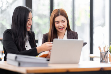 Business financing accounting banking concept. Two asian Business doing finances and calculate on desk about cost at workplace. Business working on desk with using calculator, finance accounting.
