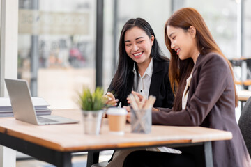 Business financing accounting banking concept. Two asian Business doing finances and calculate on desk about cost at workplace. Business working on desk with using calculator, finance accounting.
