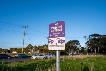 a "No Parking Anytime Tow Away Zone" sign posted on the side of the road. It indicates that unauthorized vehicles will be towed away if parked in this zone, to enforce parking regulations in the area.