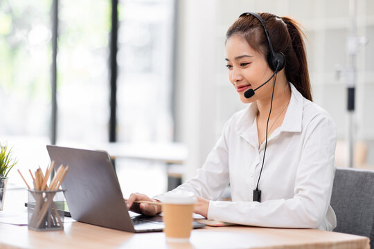 Beautiful asian female operator working laptop and call center agent  in the office. Call center customer service. Customer crm and help or support.
