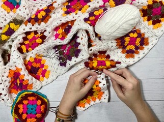 Crocheting granny square blanket process and woman's hands hobby handmade handiwork clews and hook cozy winter autumn fall photo