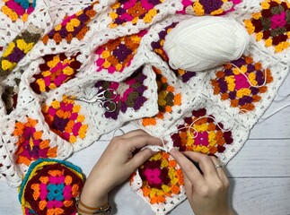 Crocheting granny square blanket process and woman's hands hobby handmade handiwork clews and hook cozy winter autumn fall photo