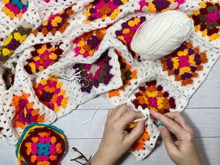 Crocheting granny square blanket process and woman's hands hobby handmade handiwork clews and hook cozy winter autumn fall photo