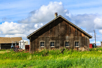 Obraz premium A large, old, wooden house with a chimney sits in a grassy field