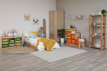 Interior of light children's room with bed, shelves and toys