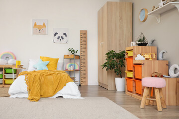 Interior of light children's room with bed, shelves and toys