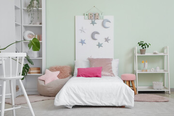 Interior of stylish children's room with bed and shelf units