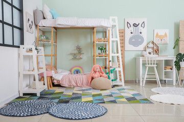 Interior of children's room with bunk bed, shelf units and table