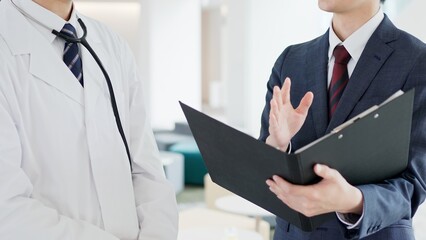 話をする医者と営業職の男性
