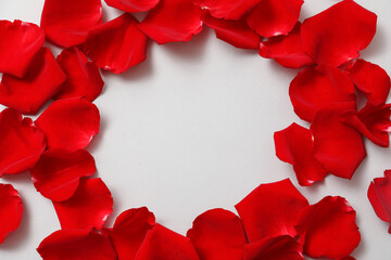 Frame made of beautiful red rose petals on grey background