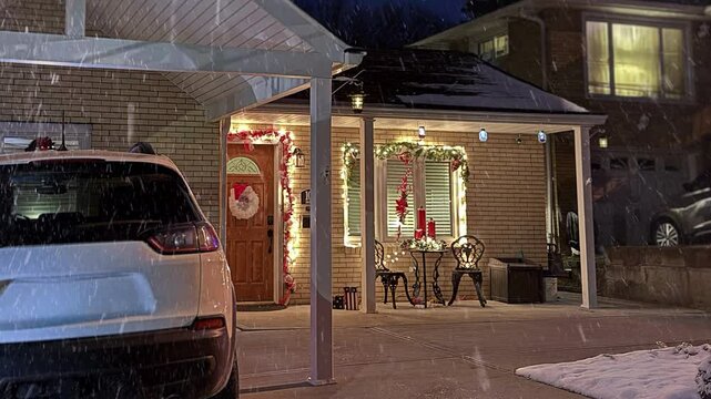 A slow nighttime zoom establishing shot of a typical New England style cape cod home decorated for Christmas during a winter snow. Pittsburgh suburbs.	